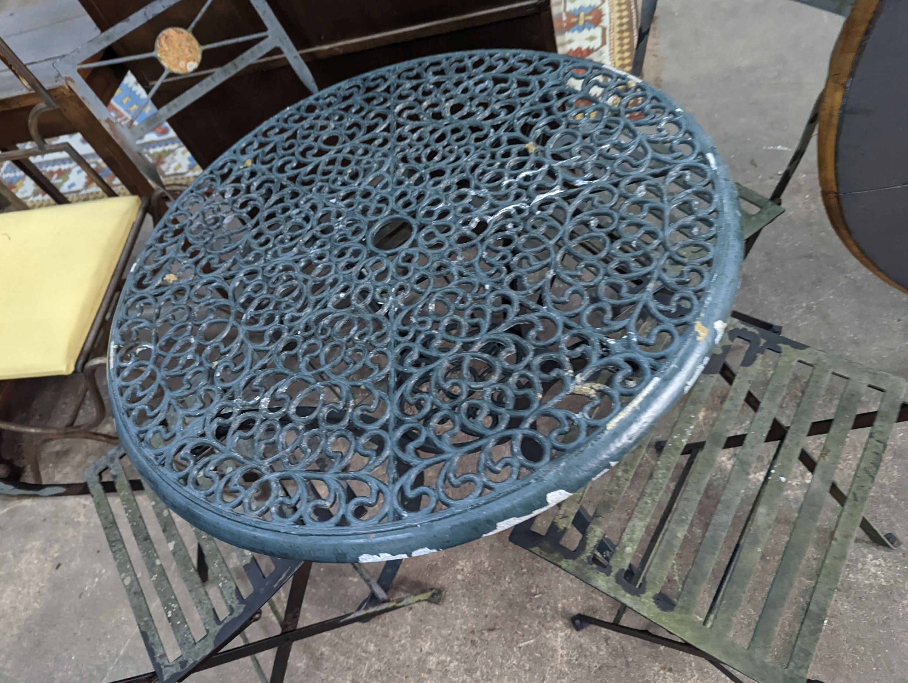 A circular aluminium garden table, diameter 74cm, height 72cm and four folding chairs